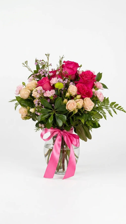 Hot pink garden roses and peach spray roses in a clear glass vase with pink ribbon — Blushing Peony Vase by Florent Floral Newmarket