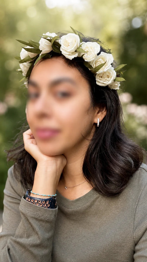 Model wearing a white rose flower crown with greenery for event photos