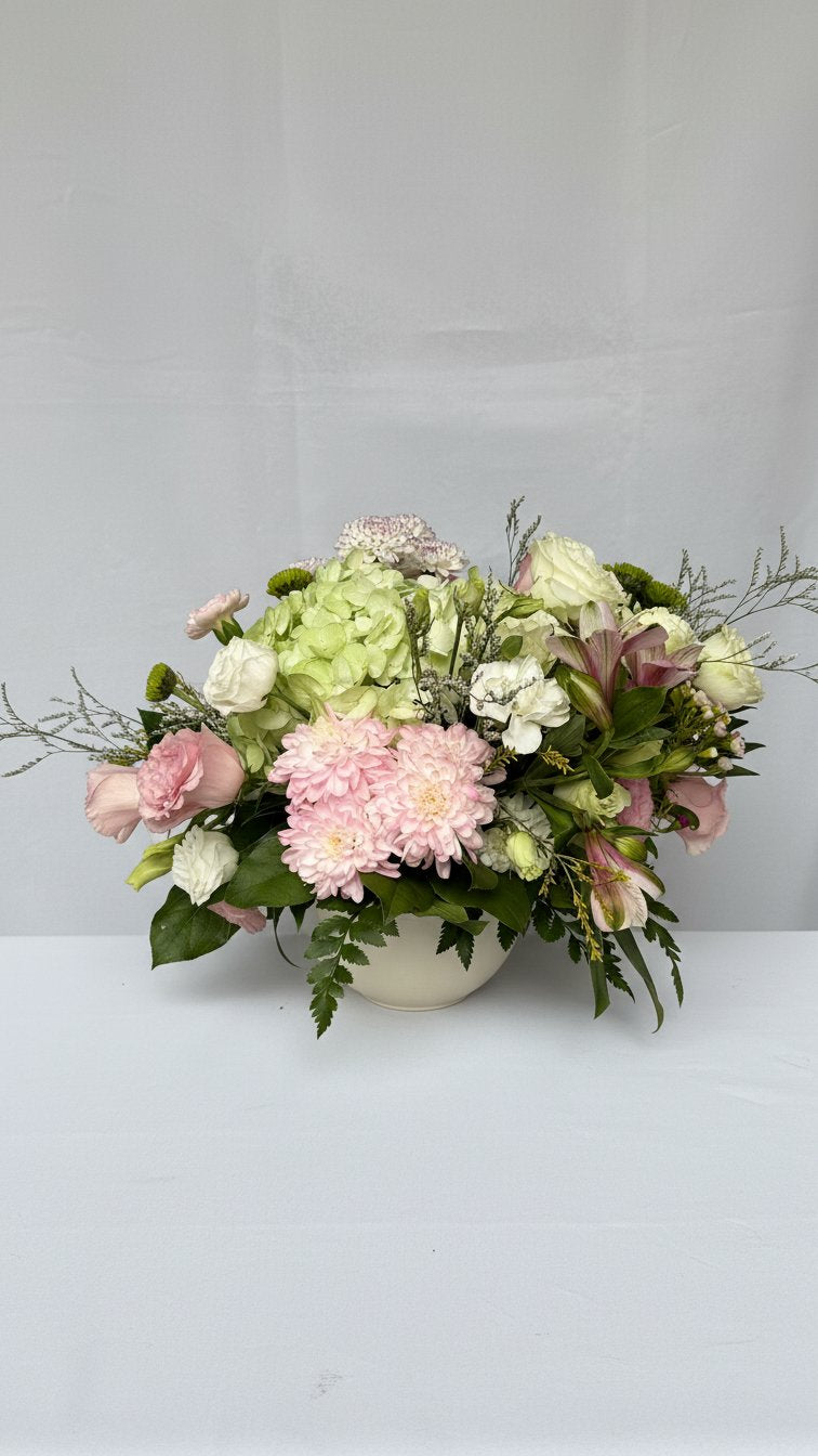 Low table centrepiece arrangement in cream ceramic bowl with roses and alstroemeria - same-day delivery Newmarket